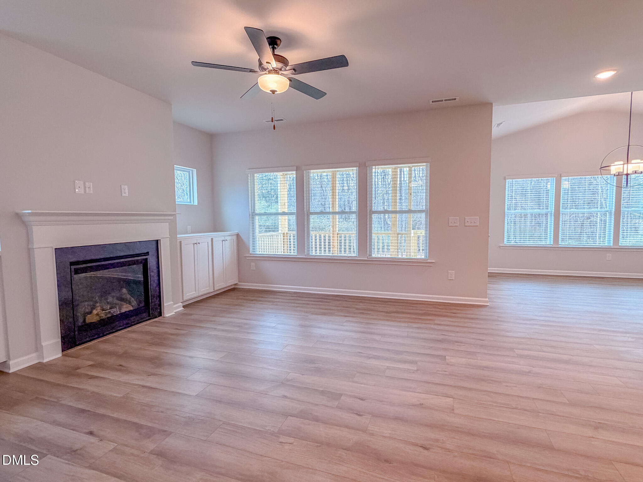 460 Beacon Hl Road Lillington, NC 27546 - Photo 11 of 48 an empty room with wooden floor fireplace and windows