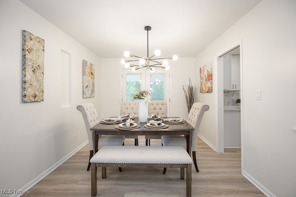 22210 Emery Road Cleveland, OH 44128 - Photo 9 of 32 Dining area featuring light lvt finished floors and a chandelier