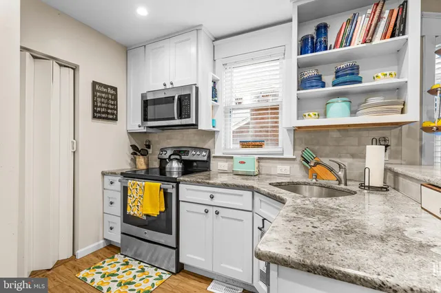 a kitchen with stainless steel appliances granite countertop a stove a sink and a microwave