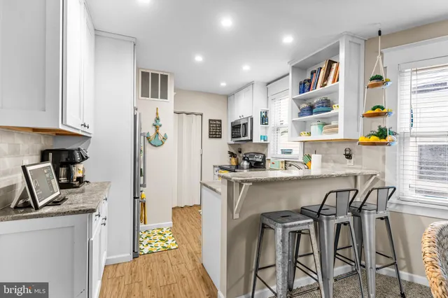a kitchen with stainless steel appliances granite countertop a refrigerator and a stove top oven