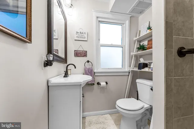 a bathroom with a toilet sink and mirror