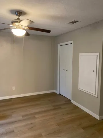 a view of a room with wooden floor and fan