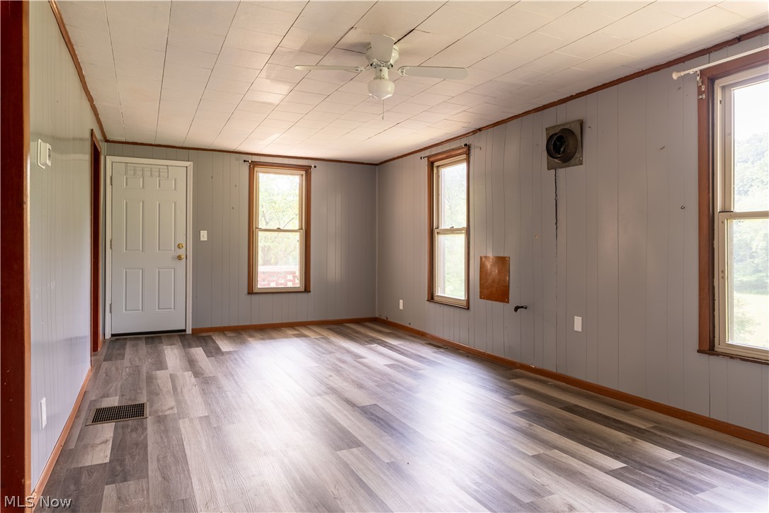 8729 Perrys Den Road Cumberland, OH 43732 - Photo 29 of 50 Empty room featuring ceiling fan, hardwood / wood-style flooring, crown molding, and plenty of natural light
