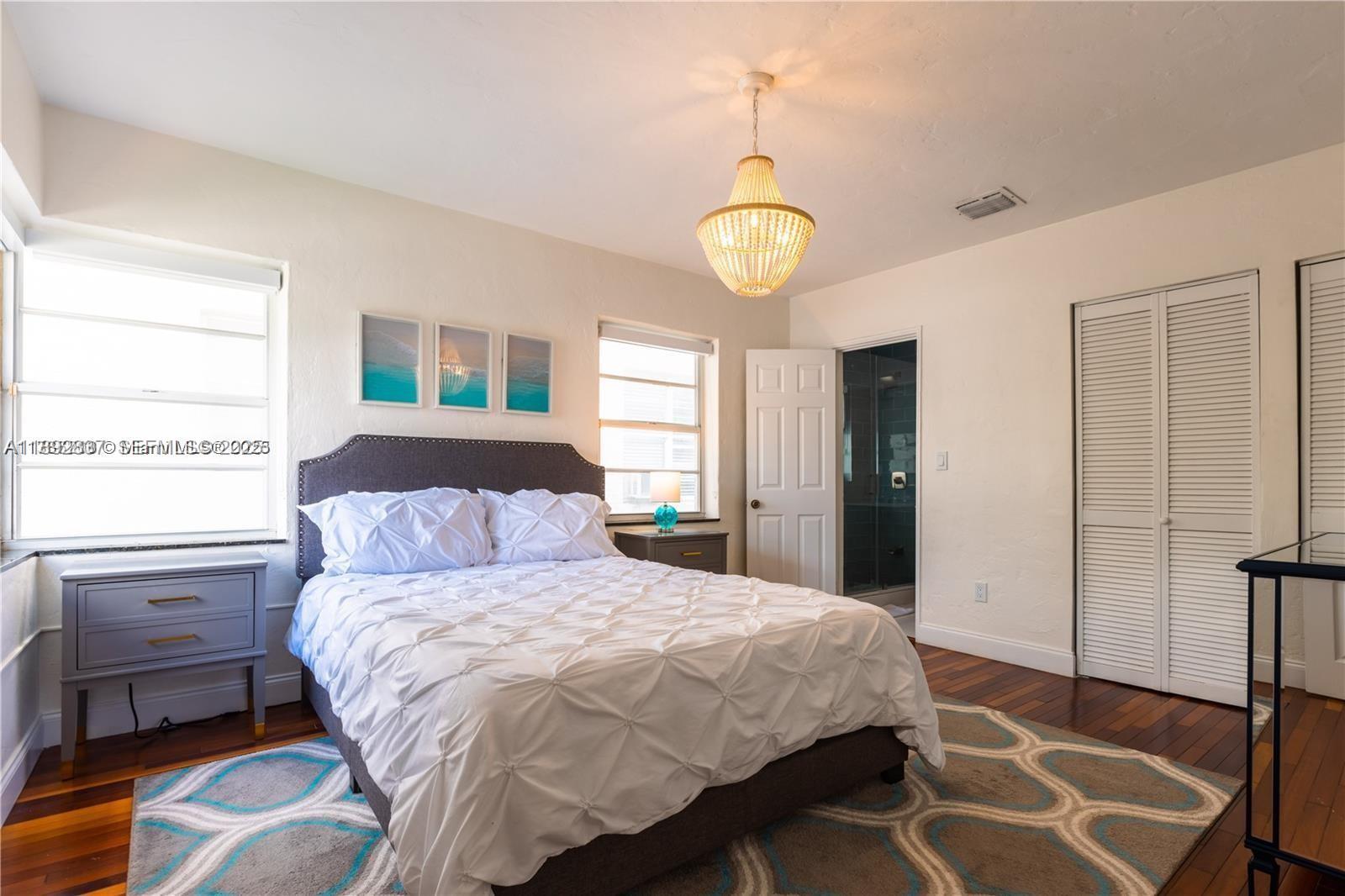 426 Northeast 26th Street, Unit 1 Miami, FL 33137 - Photo 10 of 23 a bedroom with a bed and wooden floor