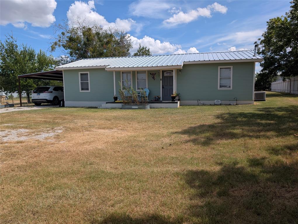 a view of a house with a backyard and a tree