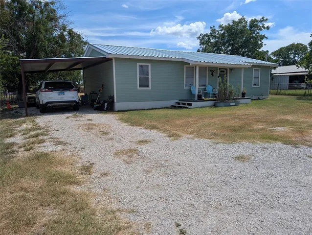 a view of house with car parked in front of house
