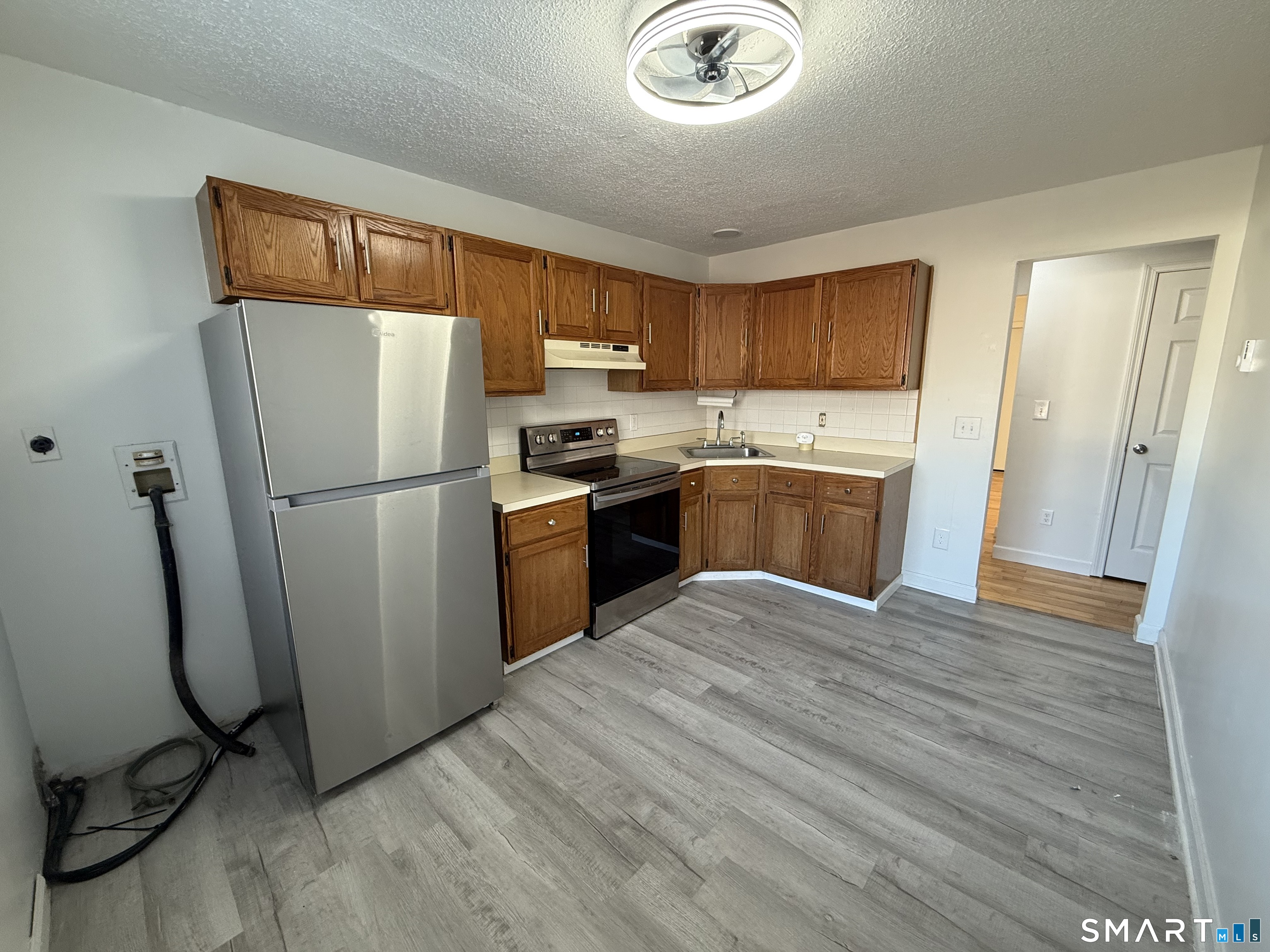 264 Scott Road, Unit 7 Waterbury, CT 06705 - Photo 1 of 10 a kitchen with stainless steel appliances granite countertop a refrigerator a sink a stove a microwave and island