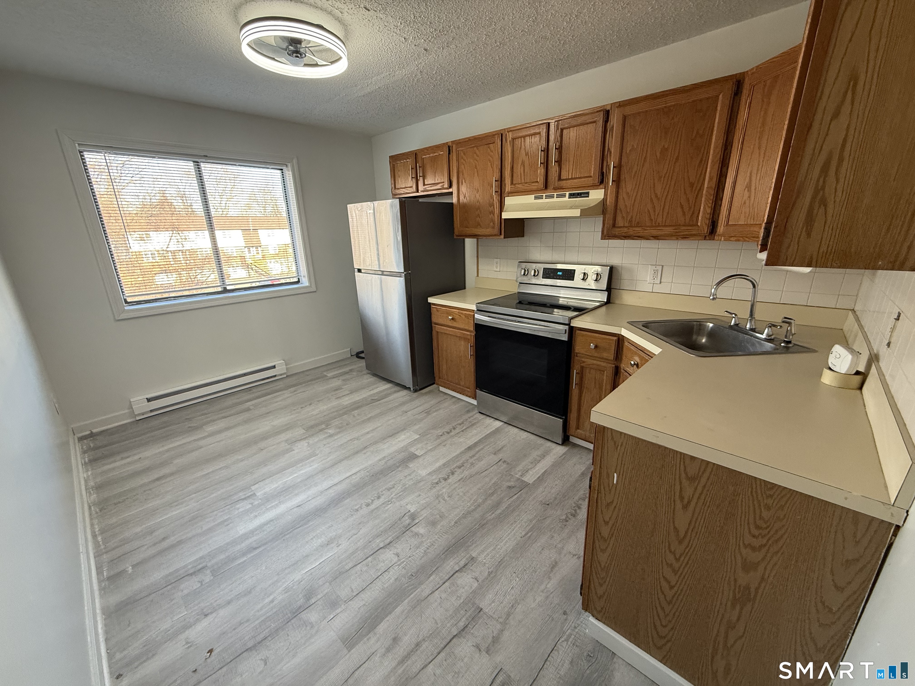 264 Scott Road, Unit 7 Waterbury, CT 06705 - Photo 2 of 10 a kitchen with a sink a stove a refrigerator cabinets and a window