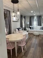 a dining room with furniture a chandelier and window