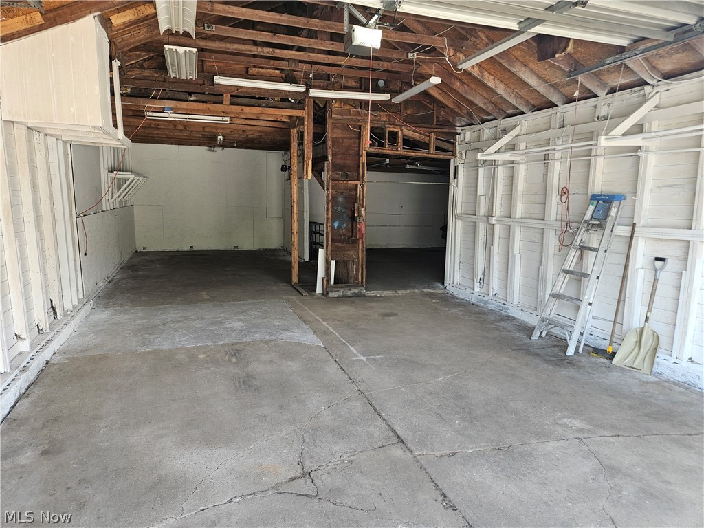 753 West River Road North Elyria, OH 44035 - Photo 25 of 28 Spacious garage area featuring concrete flooring and exposed wood ceiling beams