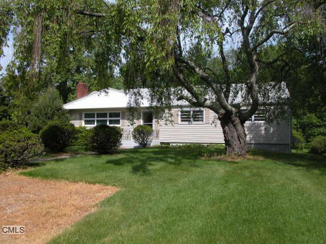 a front view of a house with a yard and trees