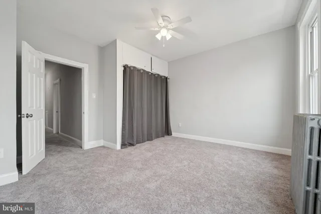 an empty room with a ceiling fan and a window