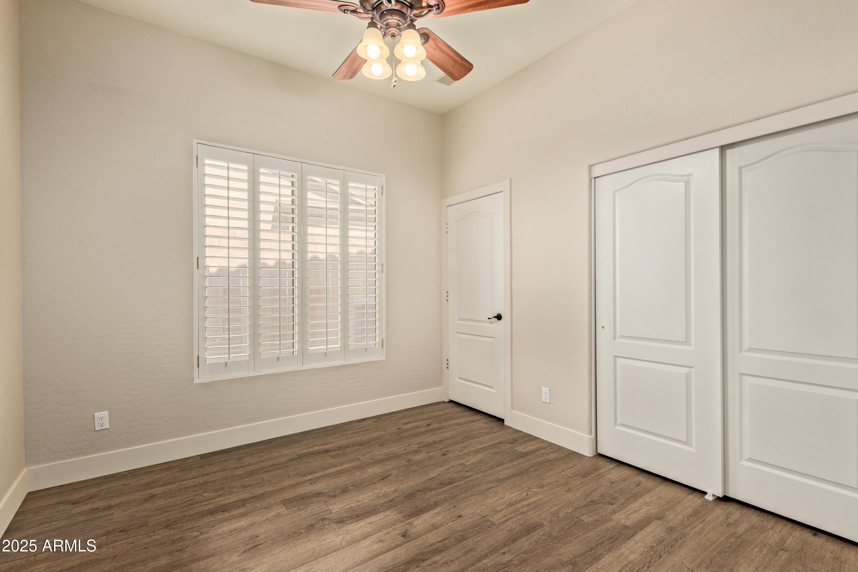 3060 North Ridgecrest, Unit 171 Mesa, AZ 85207 - Photo 11 of 31 a view of an empty room with wooden floor and a window