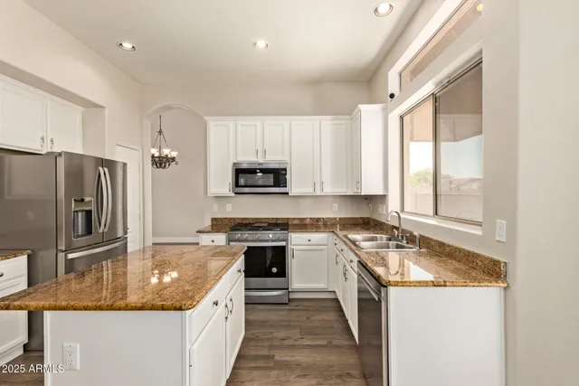 a kitchen with stainless steel appliances granite countertop a sink stove and refrigerator