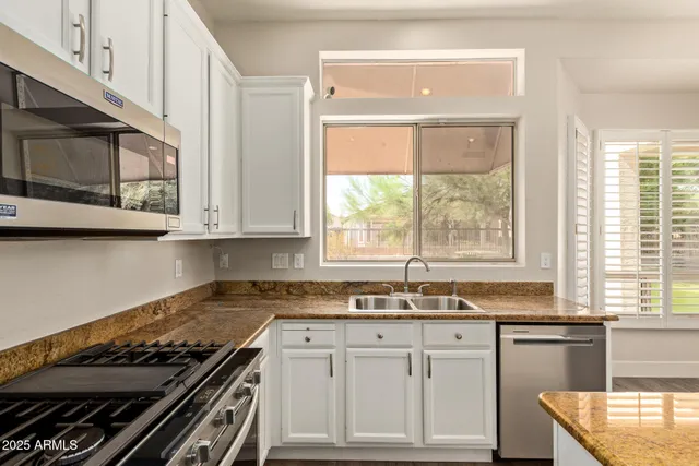 a kitchen with granite countertop a stove a sink and a granite counter tops