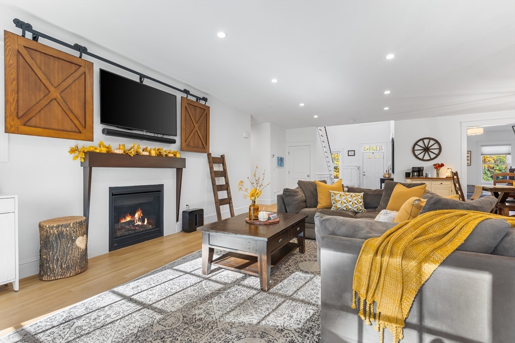 7 Heather Drive Andover, MA 01810 - Photo 12 of 42 a living room with furniture a fireplace and a flat screen tv