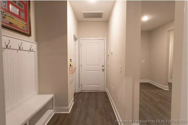 a view of a hallway with wooden floor and cabinet