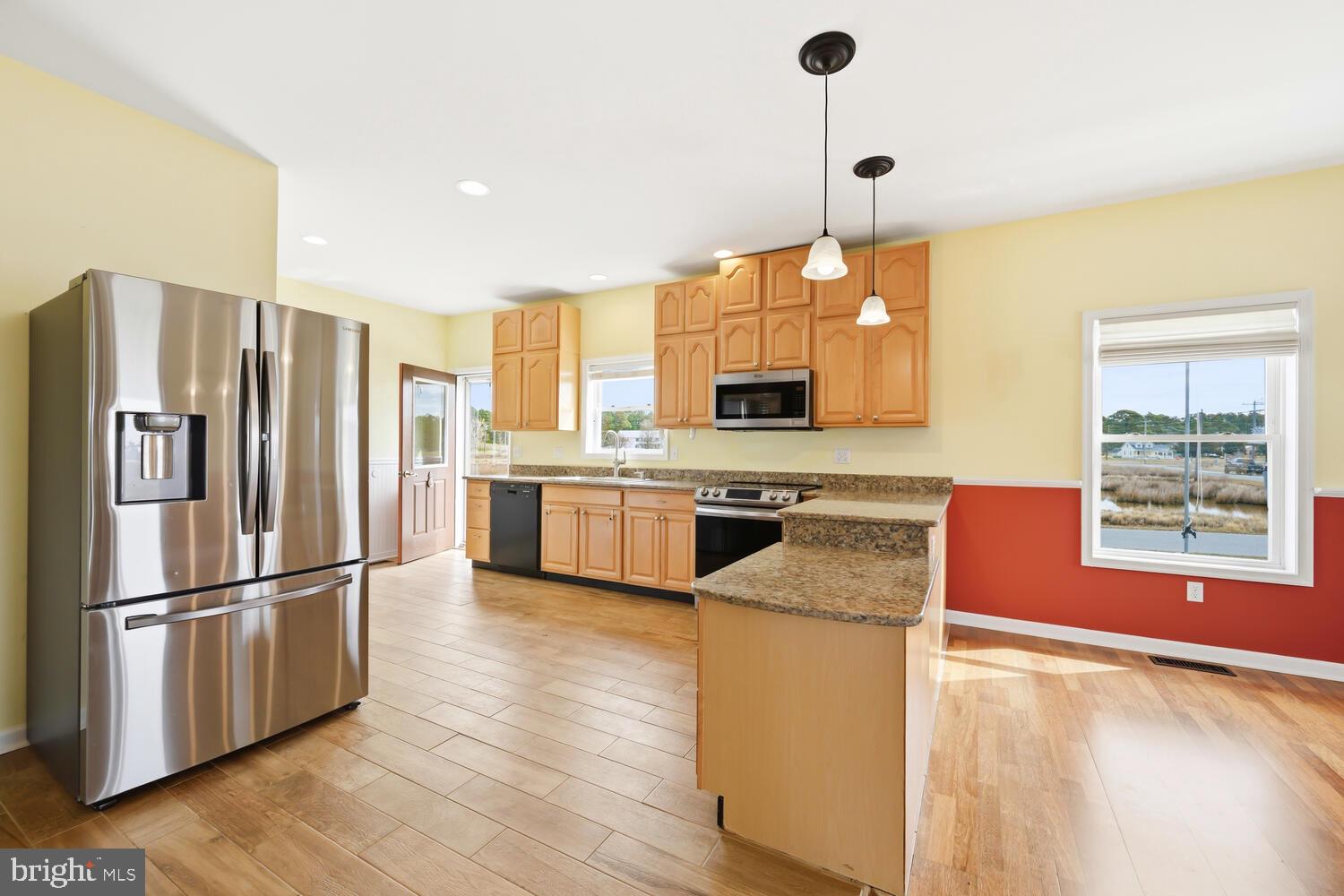 2576 Hoopers Island Road Fishing Creek, MD 21634 - Photo 14 of 43 a kitchen with stainless steel appliances granite countertop a refrigerator a stove a sink dishwasher and a refrigerator with wooden floor