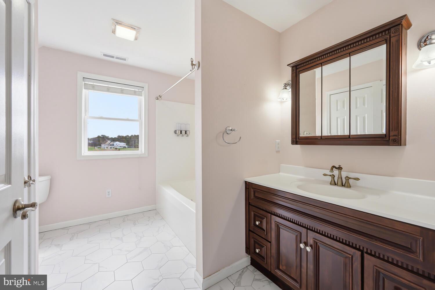 2576 Hoopers Island Road Fishing Creek, MD 21634 - Photo 30 of 43 a bathroom with a sink a mirror and a window