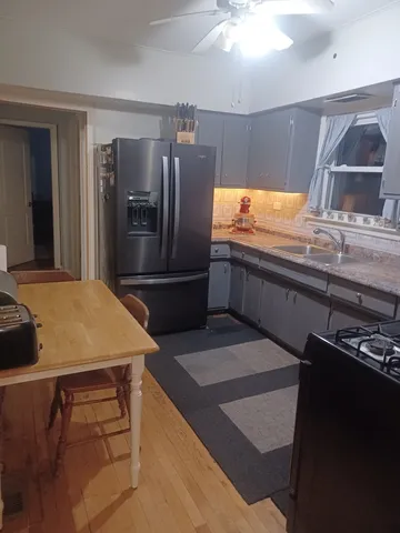 a kitchen with kitchen island a counter top space cabinets and stainless steel appliances