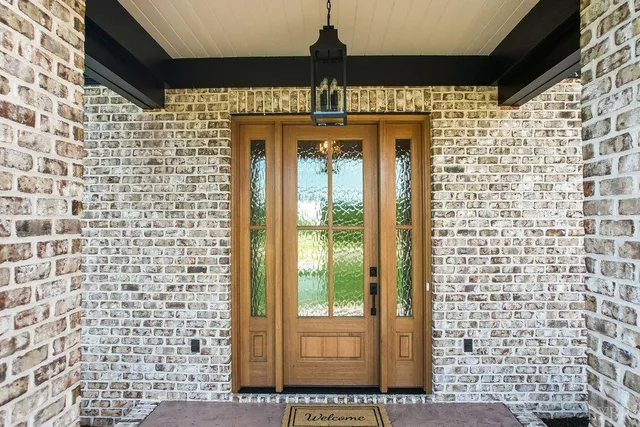 a view of an empty room with glass door and wooden floor