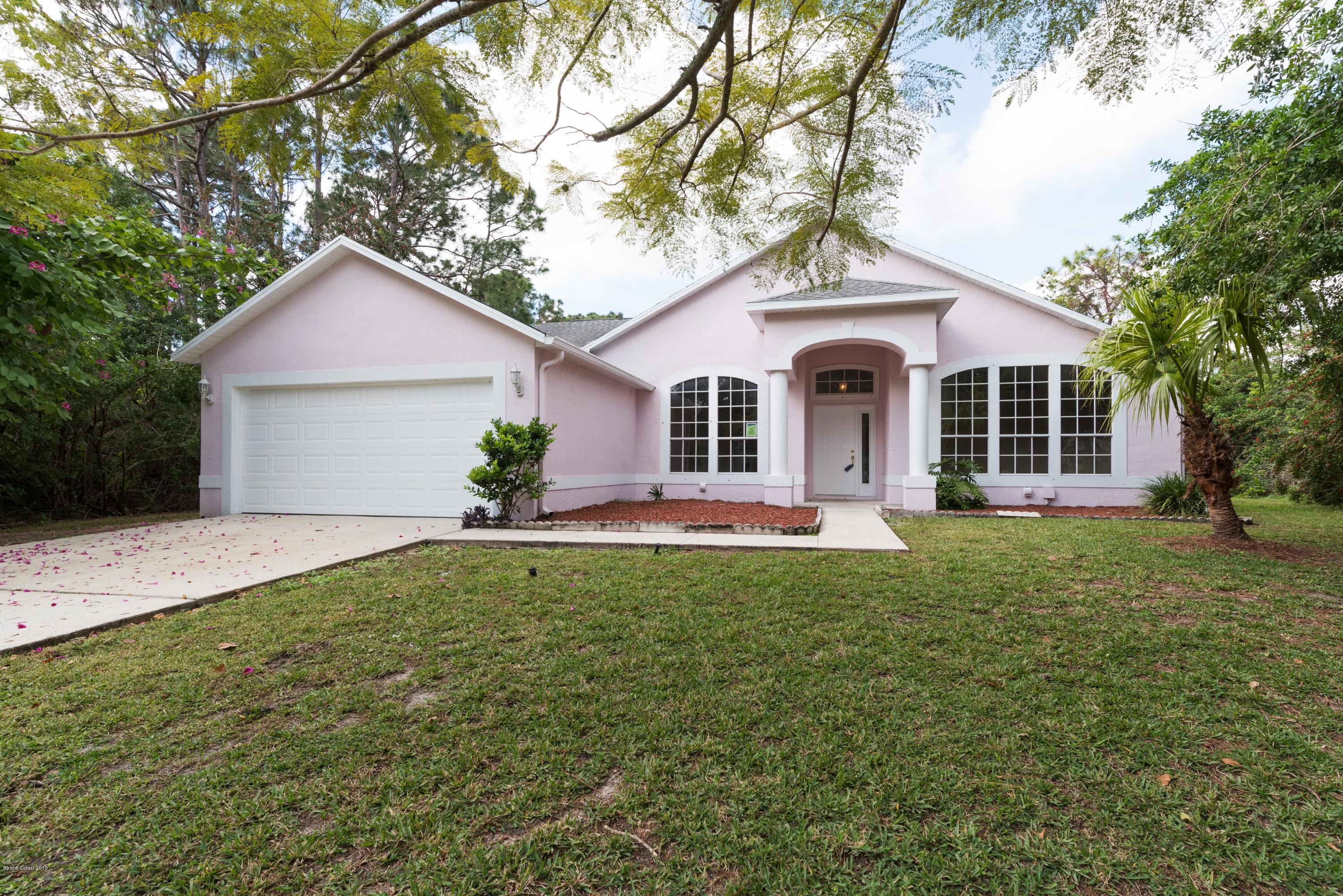 1208 Stadt Road Northwest Palm Bay, FL 32907 - Photo 1 of 24 a front view of a house with a garden and yard