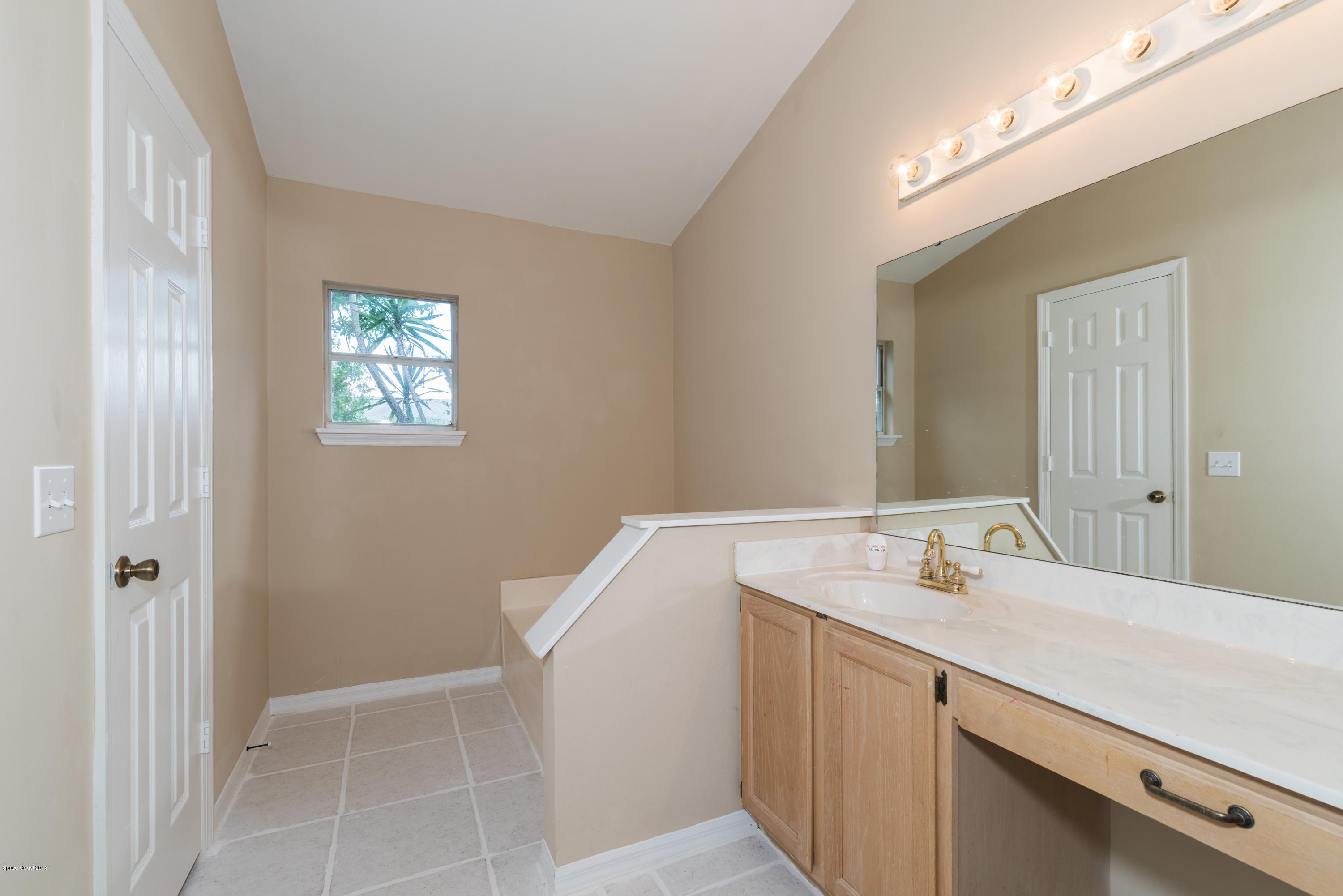 1208 Stadt Road Northwest Palm Bay, FL 32907 - Photo 13 of 24 a bathroom with a sink a toilet and a mirror