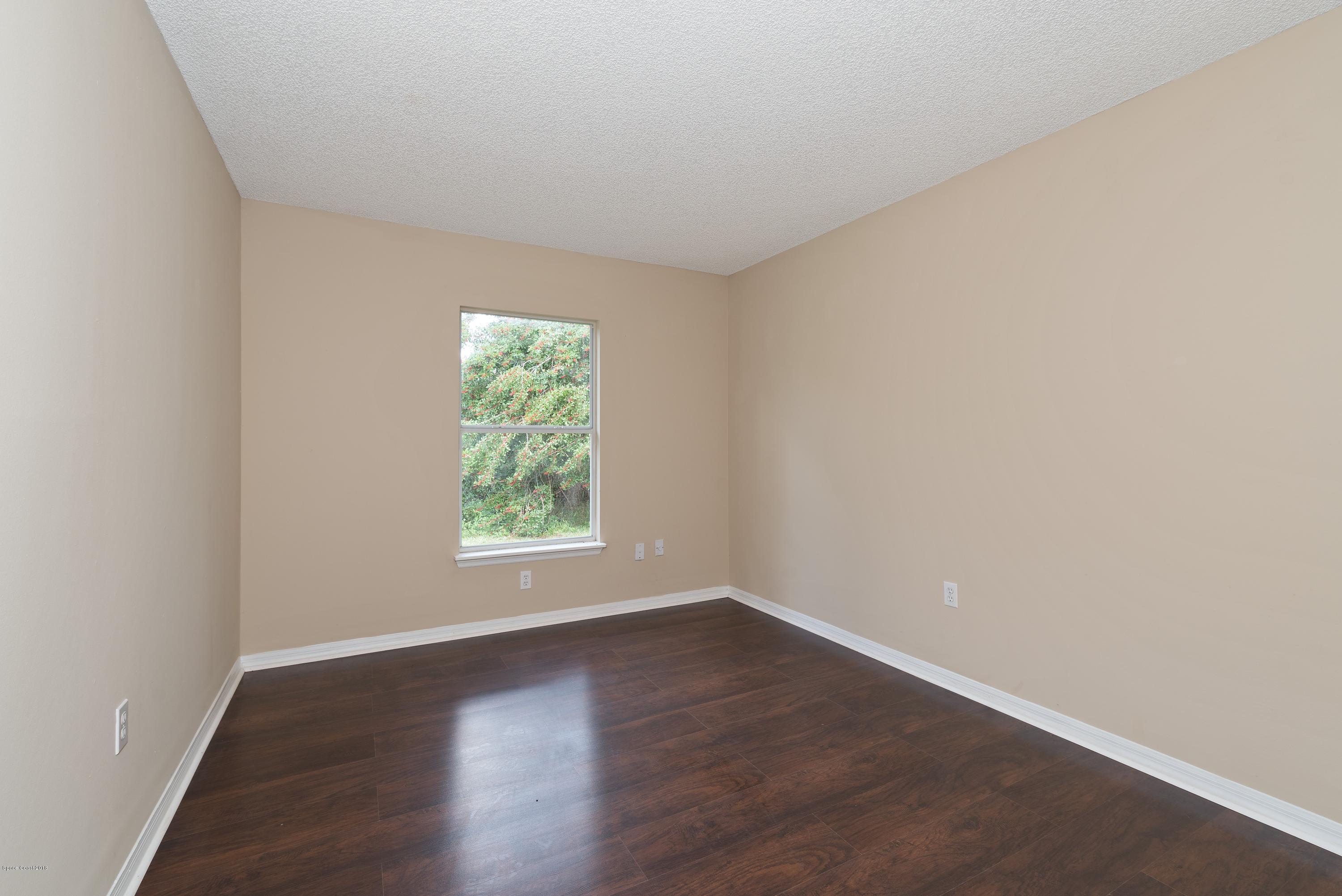 1208 Stadt Road Northwest Palm Bay, FL 32907 - Photo 14 of 24 an empty room with wooden floor and window