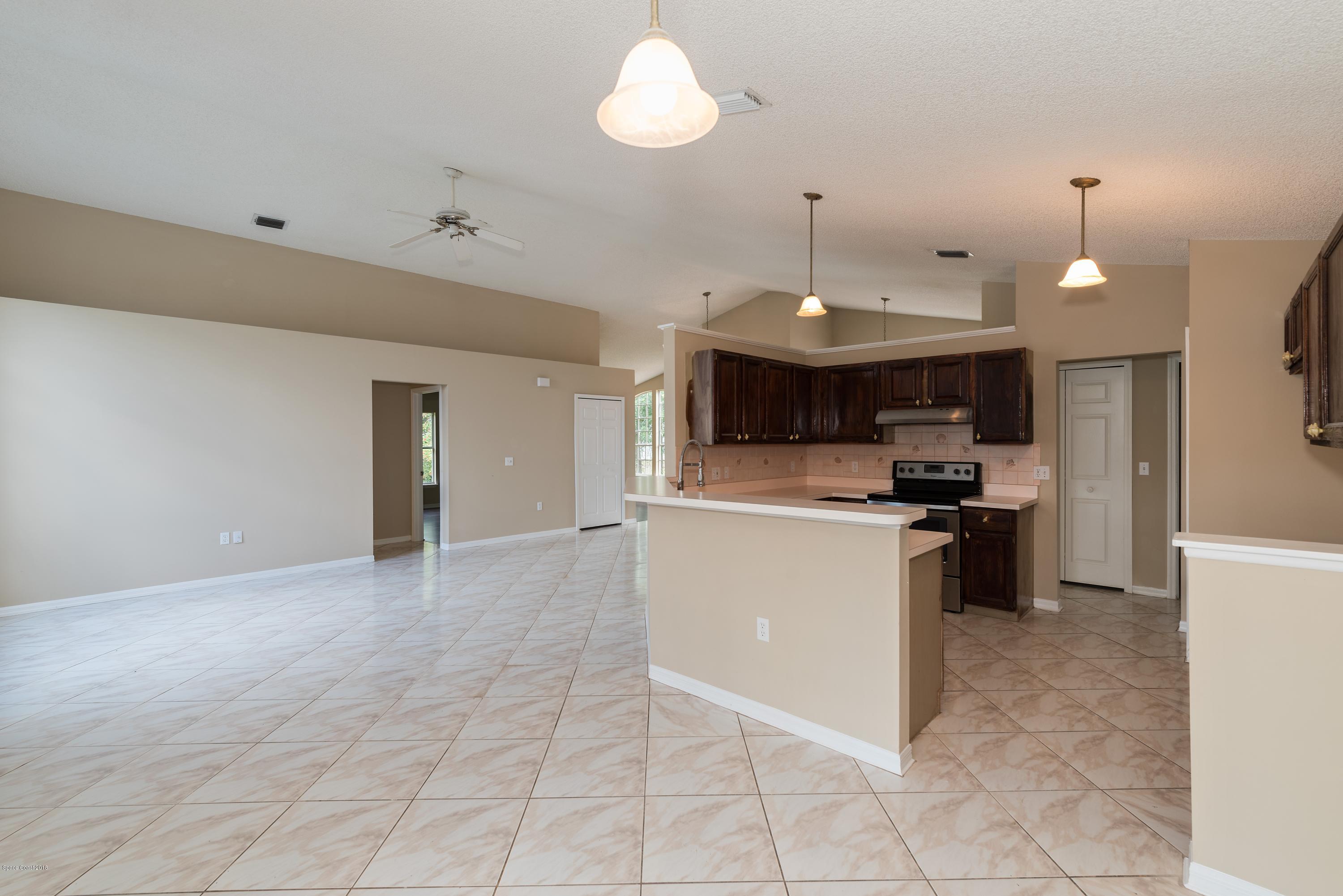 1208 Stadt Road Northwest Palm Bay, FL 32907 - Photo 18 of 24 a kitchen with a sink stainless steel appliances a counter top space cabinets and a ceiling fan