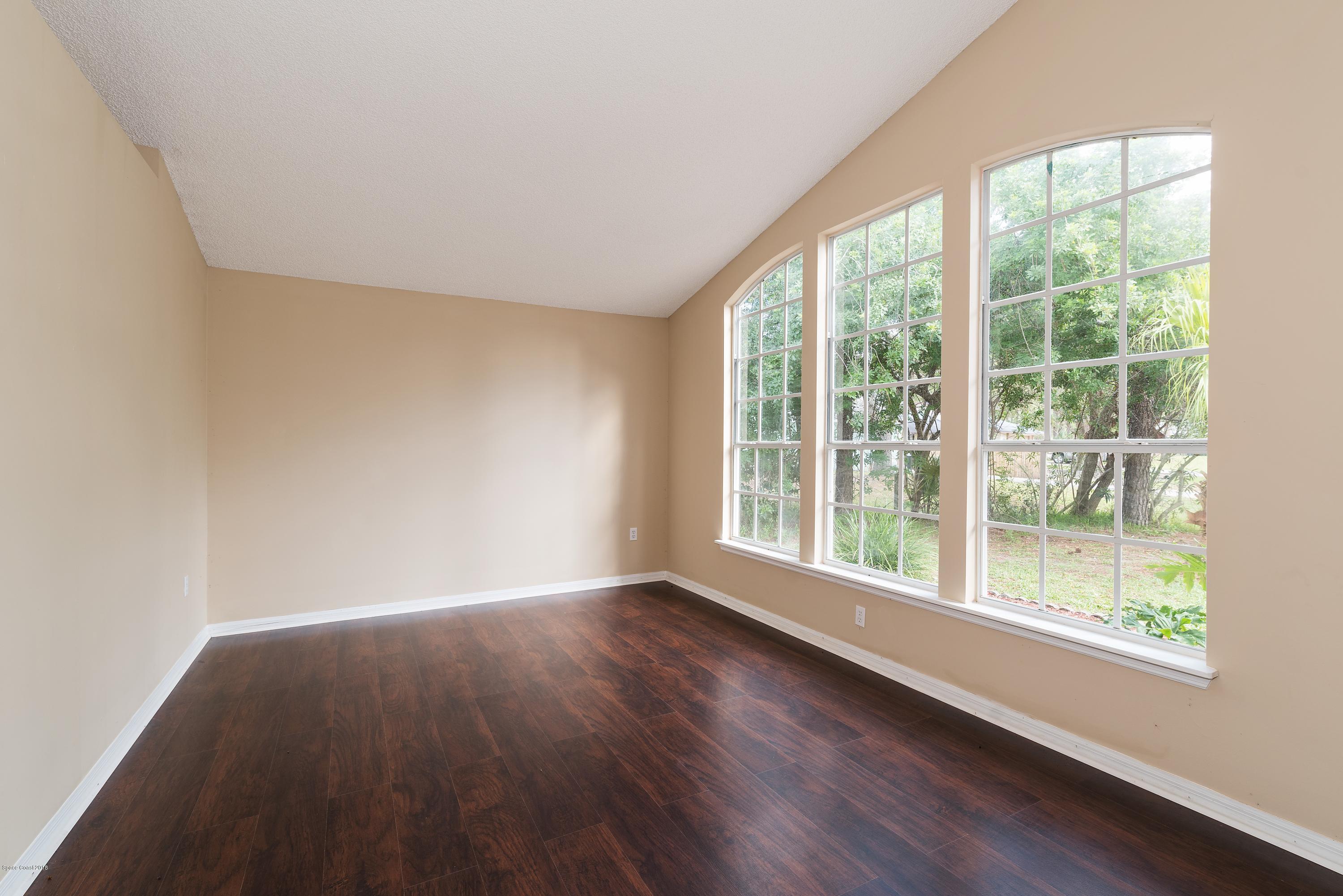 1208 Stadt Road Northwest Palm Bay, FL 32907 - Photo 3 of 24 a view of an empty room with wooden floor and a window