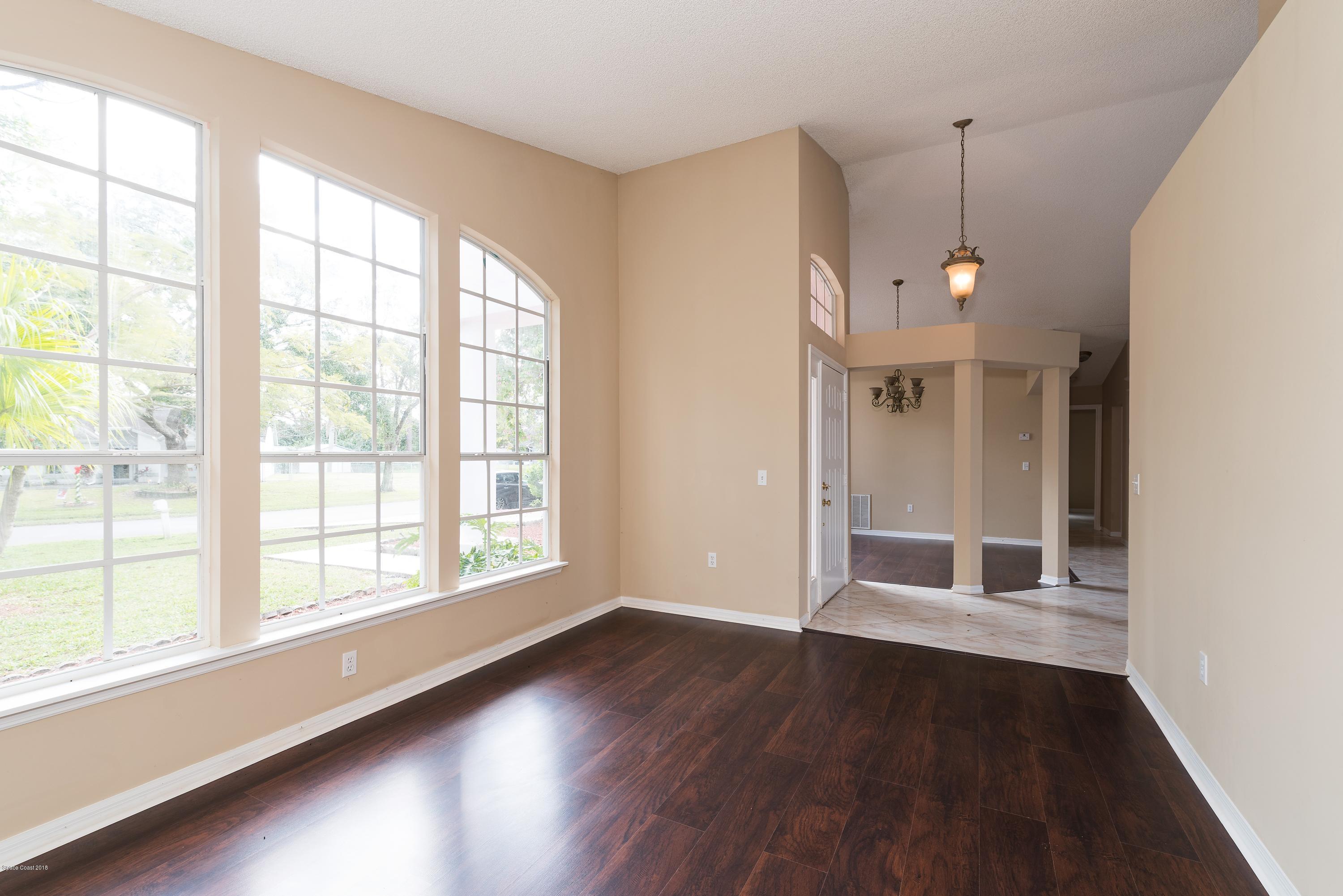 1208 Stadt Road Northwest Palm Bay, FL 32907 - Photo 4 of 24 a view of an empty room with wooden floor and a window