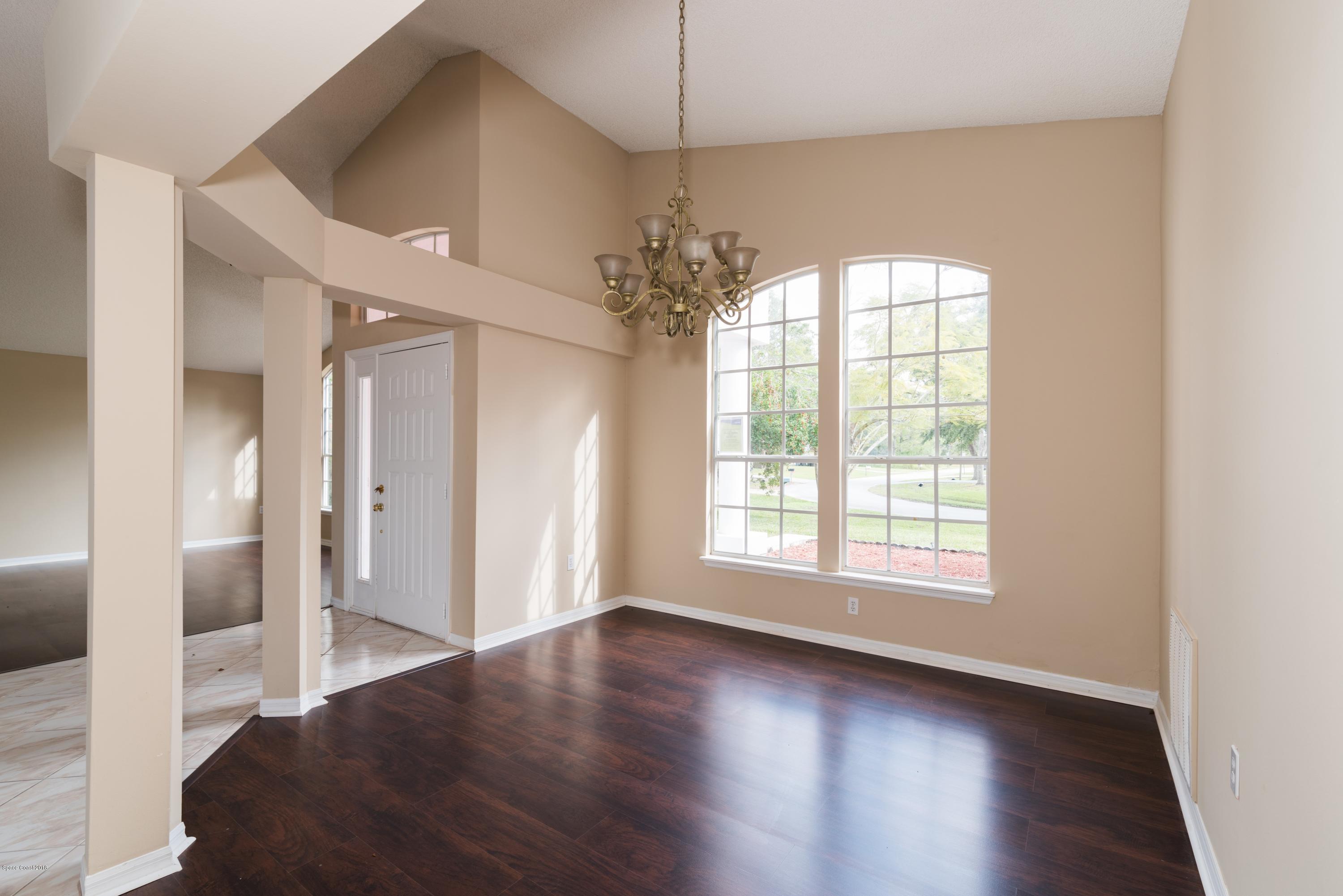 1208 Stadt Road Northwest Palm Bay, FL 32907 - Photo 5 of 24 an empty room with wooden floor and windows
