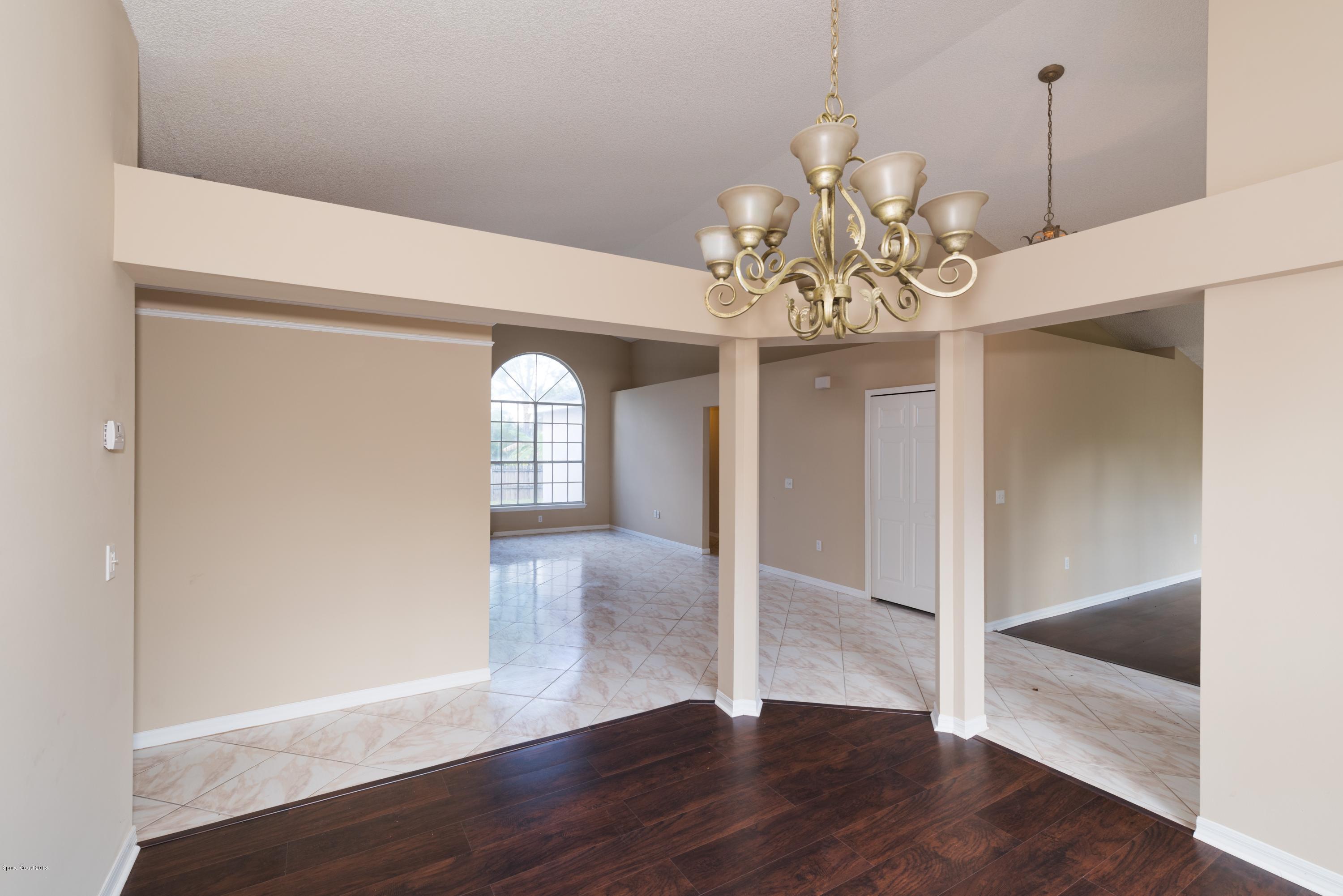 1208 Stadt Road Northwest Palm Bay, FL 32907 - Photo 6 of 24 a view of a hallway with wooden floor and chandelier
