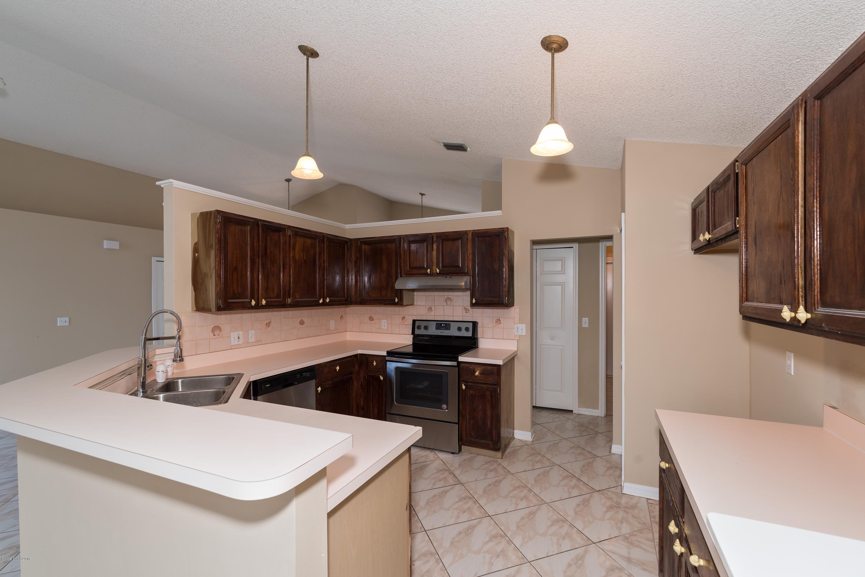 1208 Stadt Road Northwest Palm Bay, FL 32907 - Photo 9 of 24 a kitchen with kitchen island a sink stainless steel appliances and cabinets