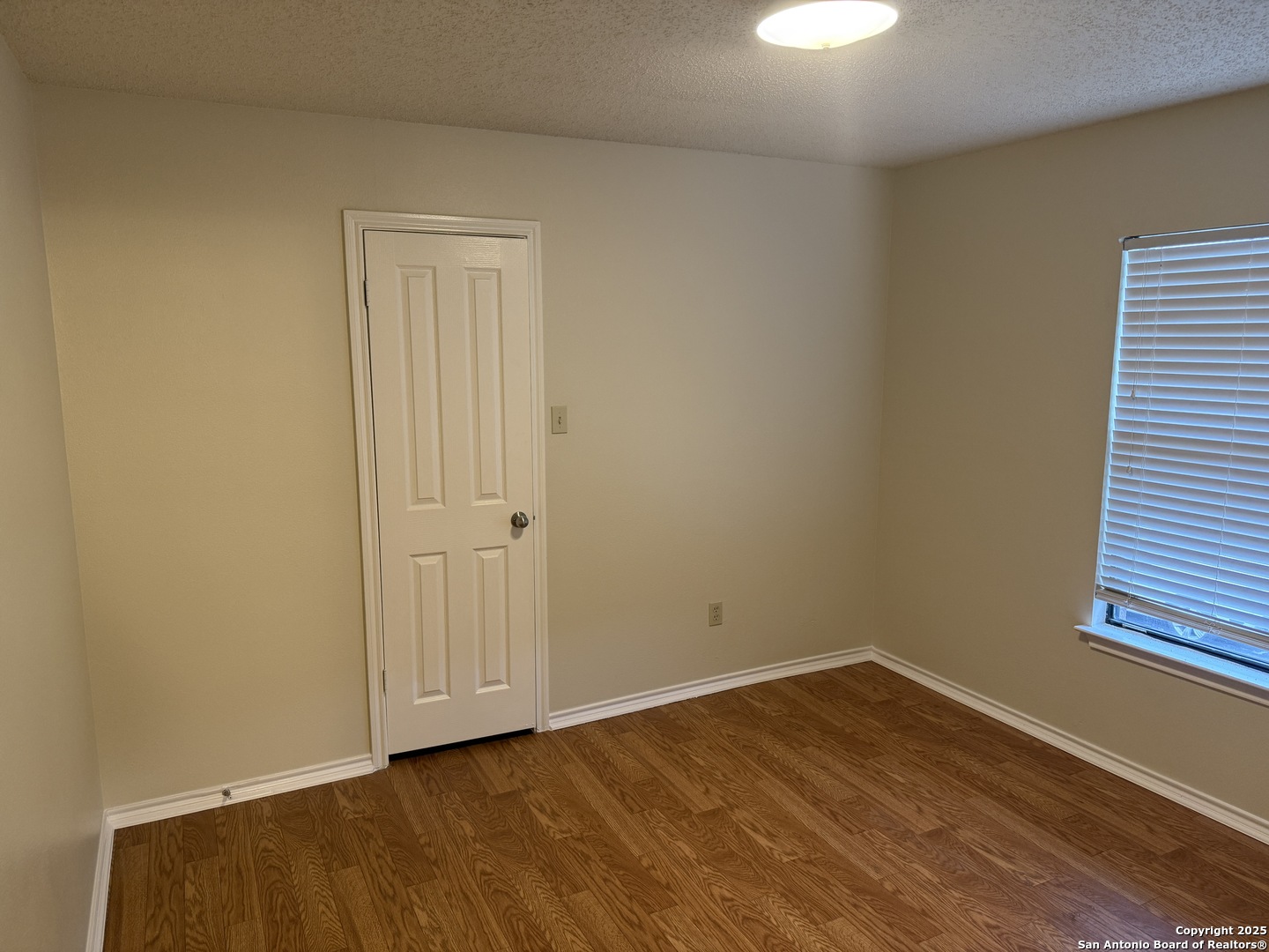 8022 Chestnut Clay Lane Converse, TX 78109 - Photo 16 of 21 a view of an empty room with wooden floor and a window