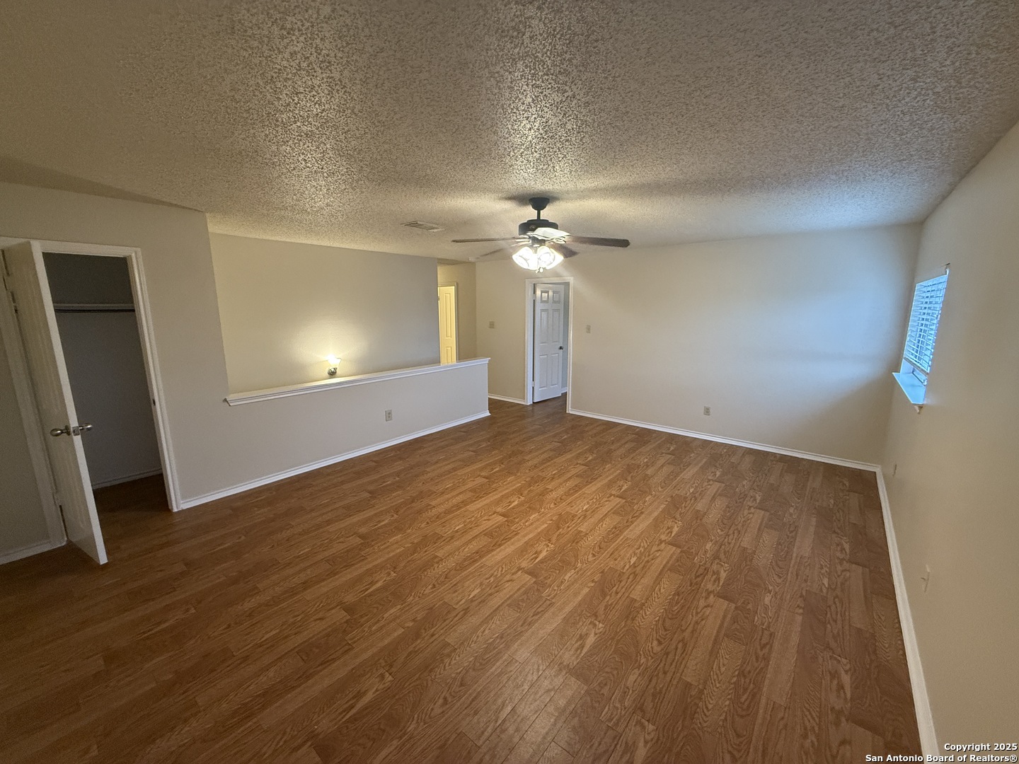 8022 Chestnut Clay Lane Converse, TX 78109 - Photo 10 of 21 an empty room with wooden floor and fan