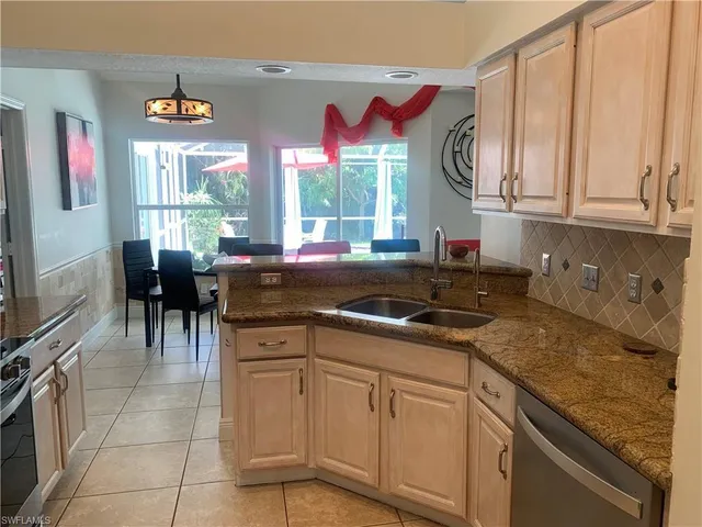 a kitchen with stainless steel appliances granite countertop a sink a stove and cabinets