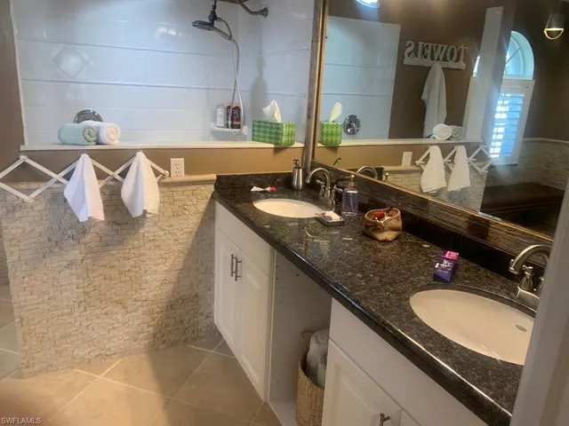 a bathroom with a granite countertop sink a toilet and mirror