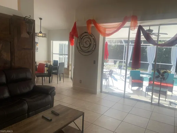 a dining room with furniture and a floor to ceiling window