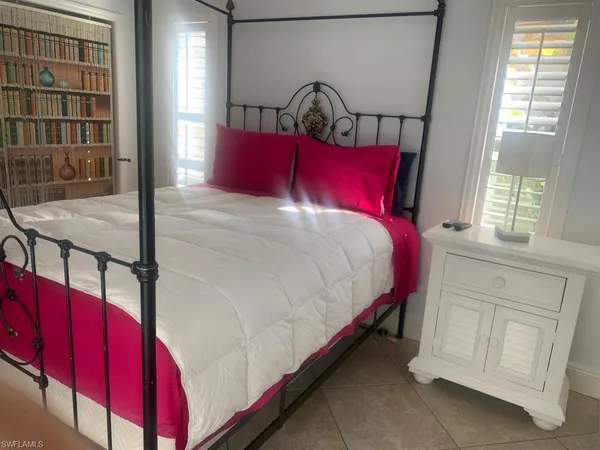 a bed sitting in a bedroom next to a window