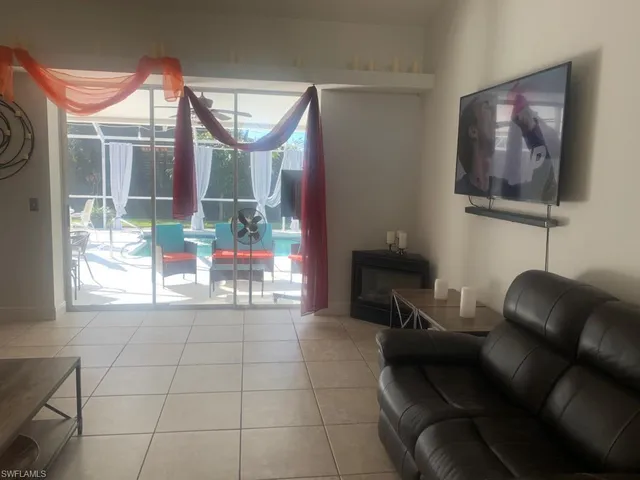 a living room with furniture a fireplace and a floor to ceiling window