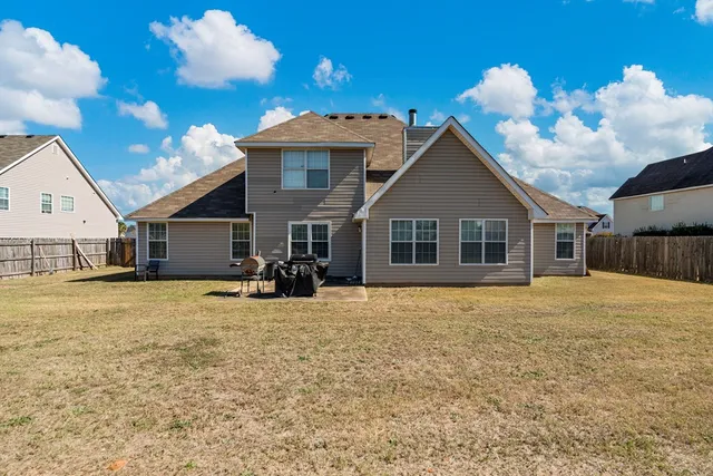 a view of a house with backyard and sitting area
