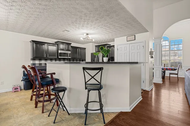 a view of a livingroom with furniture wooden floor a flat screen tv and windows