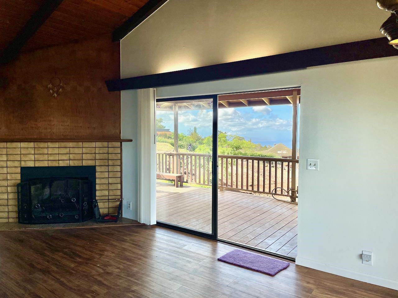 77 Kahoea Place Kula, HI 96790 - Photo 11 of 44 a view of an empty room with wooden floor and a fireplace