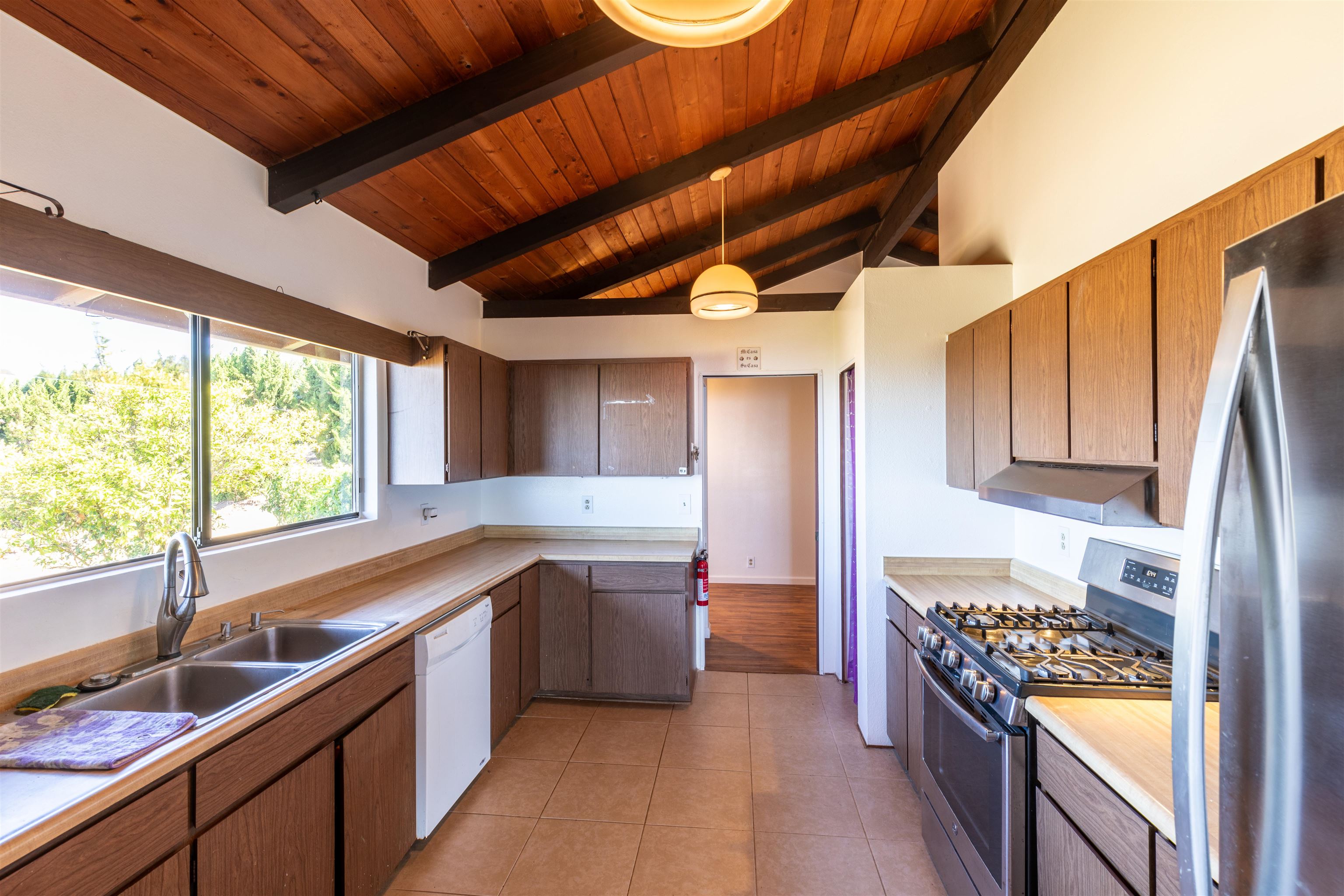 77 Kahoea Place Kula, HI 96790 - Photo 13 of 44 a kitchen with a sink a stove cabinets and a wooden floor