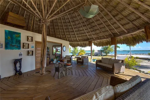a view of a patio with dining table and chairs under an umbrella with a barbeque