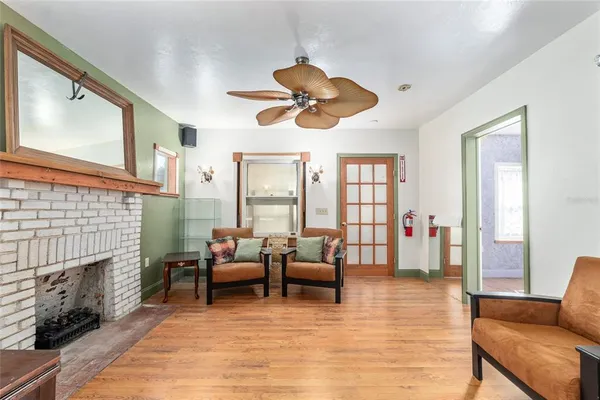 a view of a hallway with wooden floor and a kitchen space