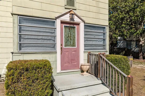 a view of a house with backyard and a tree