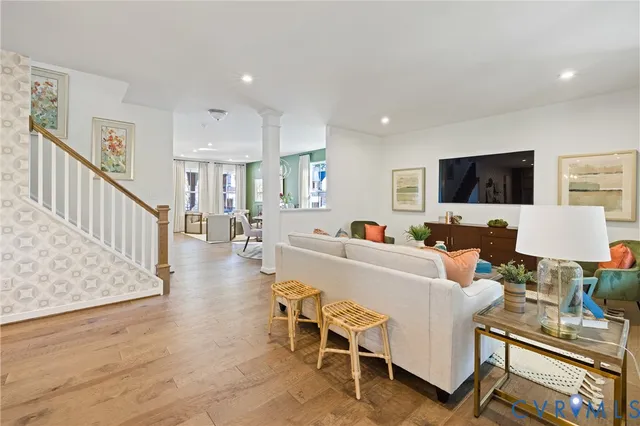 a living room with furniture a flat screen tv and kitchen view