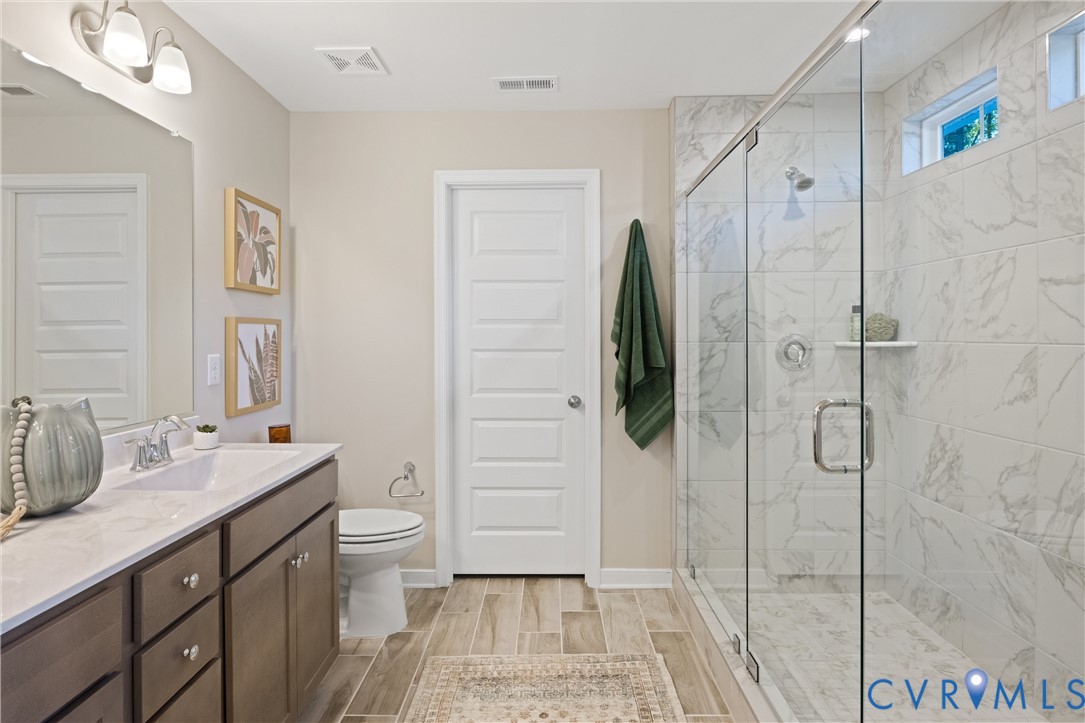 979 Charlemagne Road Midlothian, VA 23114 - Photo 27 of 50 a bathroom with a double vanity sink toilet and shower